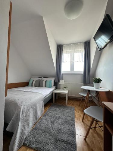 a small bedroom with a bed and a window at Pensjonat Melodia in Pobierowo