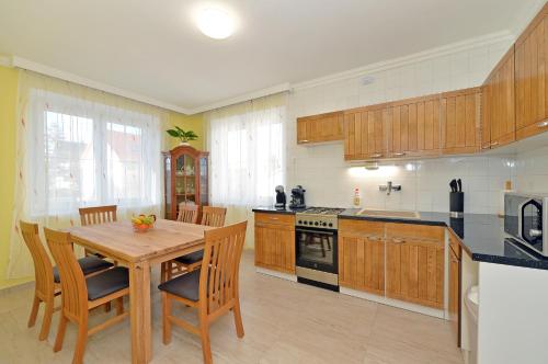 duża kuchnia z drewnianym stołem i krzesłami w obiekcie Blackbird Apartment w Balatonfüred