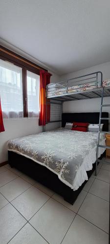 une chambre avec deux lits superposés et une fenêtre dans l'établissement Bourg-St-Maurice/ Les Arcs - Appartement 5 Personnes, à Bourg-Saint-Maurice