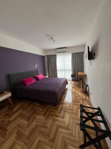 a bedroom with a bed with pink pillows on it at Columbia Palace Hotel in Buenos Aires