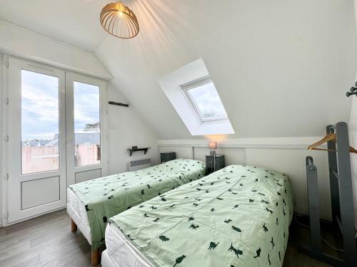 1 Schlafzimmer mit 2 Betten und einem Fenster in der Unterkunft Charmant T3 duplex 2 Bord de mer Terrasse in Quiberon