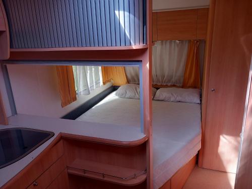 a small room with a bed and a sink at Caravan near the sea 4 in Ugljan