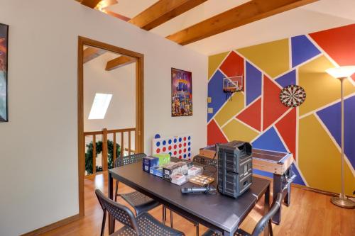 a dining room with a table and a colorful wall at Poconos Cabin Serene Deck, Fire Pit and Game Room in Tobyhanna