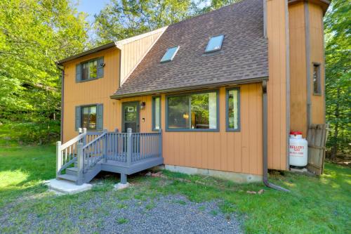 a small yellow house with a porch and windows at Poconos Cabin Serene Deck, Fire Pit and Game Room in Tobyhanna