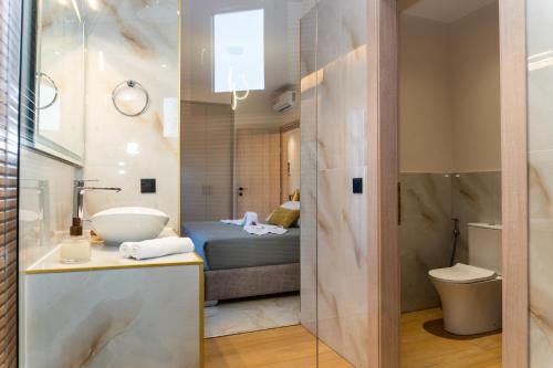 un bagno con lavandino, servizi igienici e un letto di Villa Strada Castello a Città di Zante