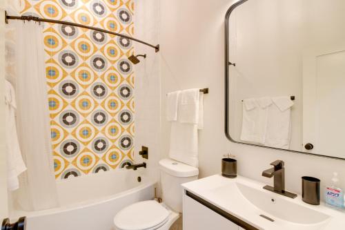 a bathroom with a sink and a toilet and a mirror at Trendy Galveston Getaway - Walk to Downtown! in Galveston