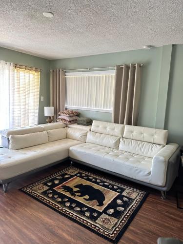 a living room with a white couch and a rug at Bearadise Retreat At English Mountain Condo in Sevierville