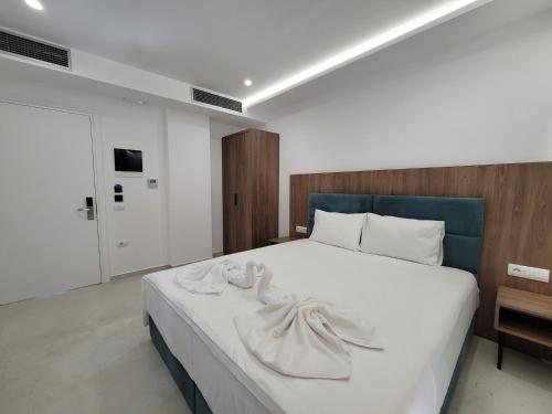 a bedroom with a large white bed with towels on it at Prestige Hotel in Ksamil