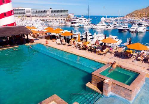 una piscina junto a un puerto deportivo con barcos en Junior Marina suite en Cabo San Lucas
