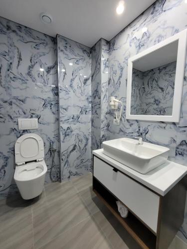 bagno con servizi igienici, lavandino e specchio di Prestige Hotel a Ksamil