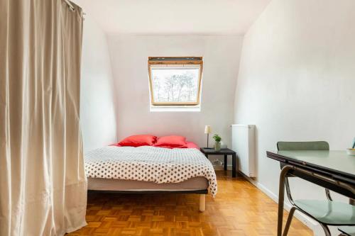 a bedroom with a bed with red pillows on it at Chbre 2P + navette CDG in Aulnay-sous-Bois