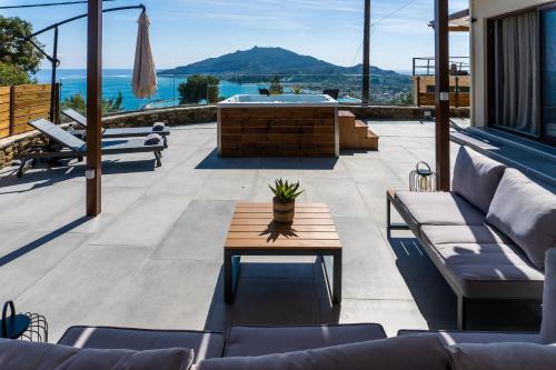 a patio with couches and a table and a hot tub at Villa Strada Castello in Zakynthos Town