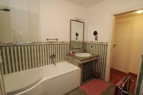 a bathroom with a tub and a sink and a mirror at Luminoso e accogliente appartamento con giardino - Battistini in Rome
