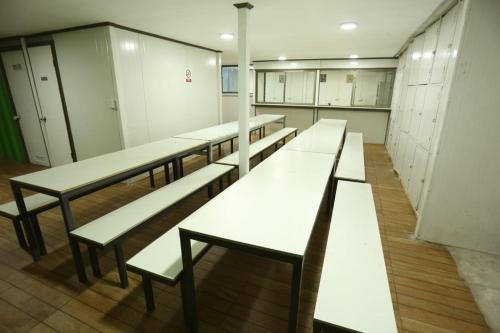 a row of white benches in a locker room at hostal ibiza in Talca