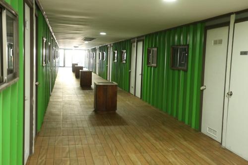 un couloir avec des murs et des bancs verts dans un bâtiment dans l'établissement hostal ibiza, à Talca