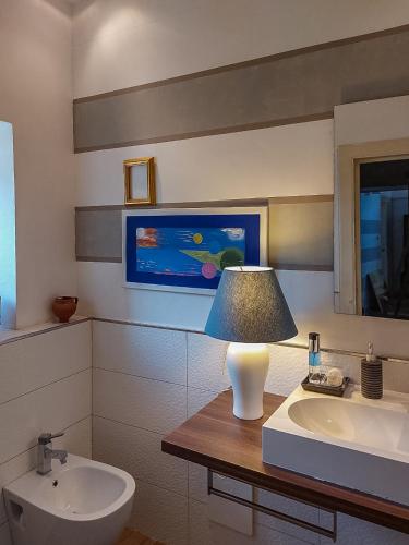 a bathroom with a lamp on a table next to a sink at Artesia - Junior Suite in Angellara