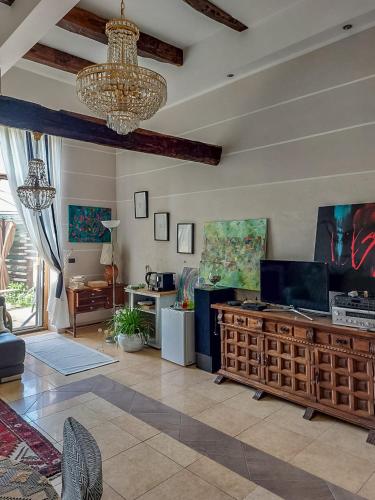 a living room with a chandelier and a couch and a table at Artesia - Junior Suite in Angellara