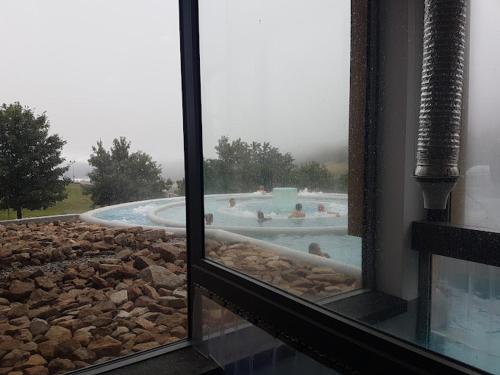 une vue d'une piscine à travers une fenêtre dans l'établissement Charmant appartement avec parking privé dans une petite résidence très calme, aux Angles