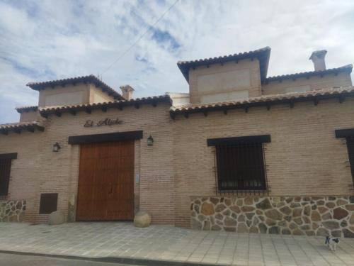 Argés的住宿－Casas rurales El Aljibe, lavanda，一座带木门的大型砖砌建筑