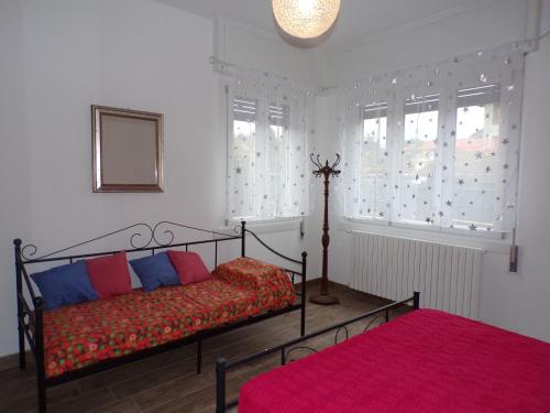 1 dormitorio con 1 cama y 2 ventanas en Casa Vacanze Terra di Mezzo, en Invorio Inferiore