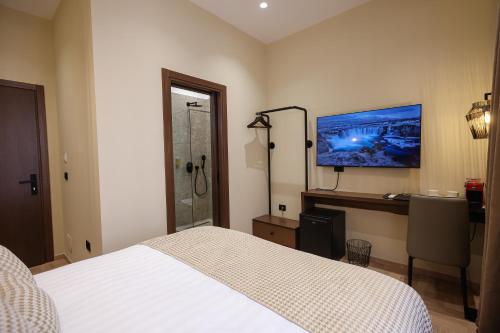 a bedroom with a bed and a tv on the wall at CLOUD 5 Blloku Rooms Tirana in Tirana