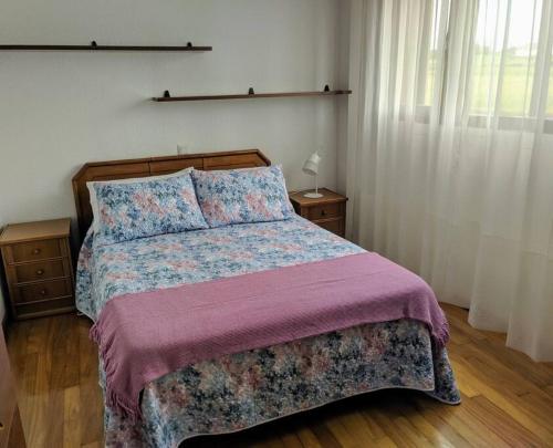 1 dormitorio con 1 cama grande con manta morada en Villa en la costa, en Santander