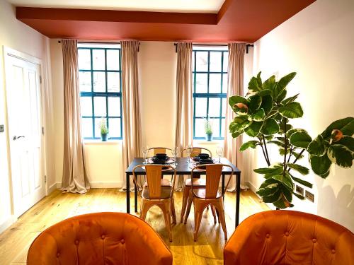 Dawn House - Wyndale Living -Bham JQ 3BR Townhouse في برمنغهام: غرفة طعام مع طاولة مع كراسي ومصنع