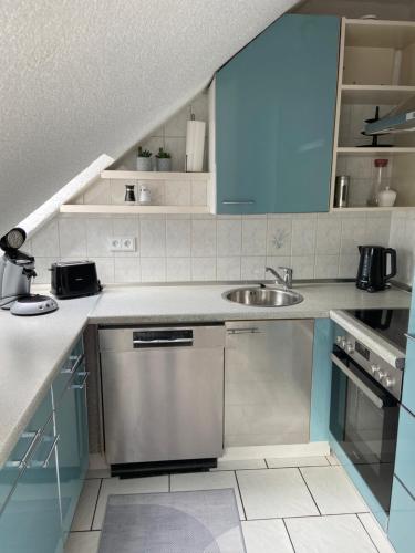 a kitchen with blue cabinets and a sink at Ferienwohnung am Erbacher Mümlingufer in Erbach im Odenwald