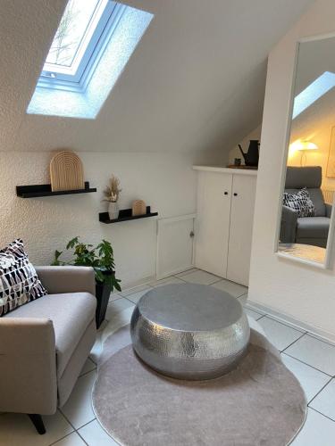 a living room with a couch and a silver table at Ferienwohnung am Erbacher Mümlingufer in Erbach im Odenwald