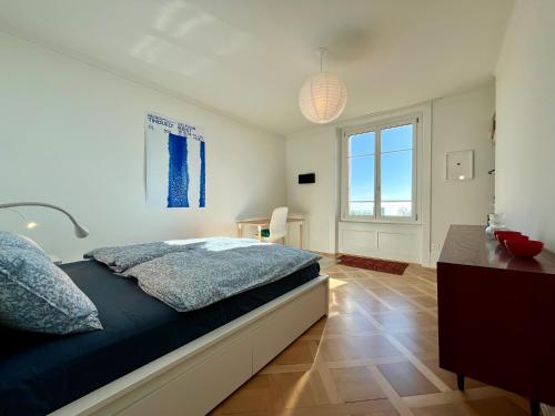 um quarto com uma cama, uma secretária e uma janela em L’Ecluse em Neuchâtel