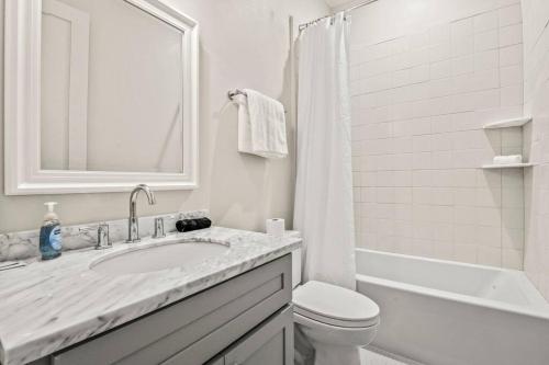 a white bathroom with a sink and a toilet at Ship Island Town Home in Pass Christian