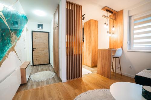 ein Wohnzimmer mit einer Holztür und einem Tisch in der Unterkunft Apartment Vila Idila in Tuzla