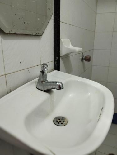 lavabo blanco en el baño con espejo en Apartamentos Ganen, en Cartagena de Indias