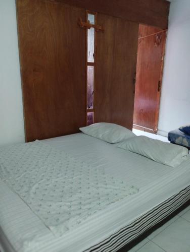 Bett in einem Zimmer mit offener Tür in der Unterkunft Apartamentos Ganen in Cartagena de Indias