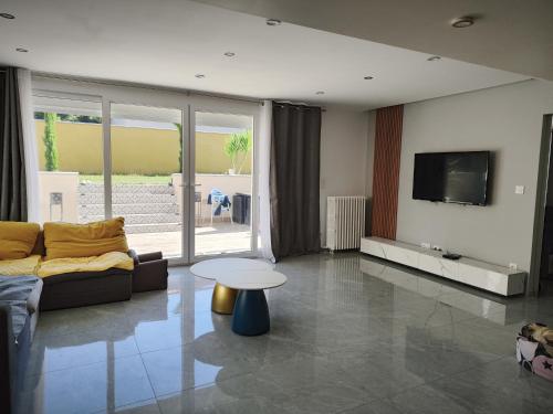 ein Wohnzimmer mit einem Sofa und einem TV in der Unterkunft Villa au porte de montchat Lyon in Bron