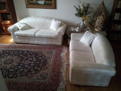 een woonkamer met twee witte banken en een tapijt bij Villa Chanel in Borno