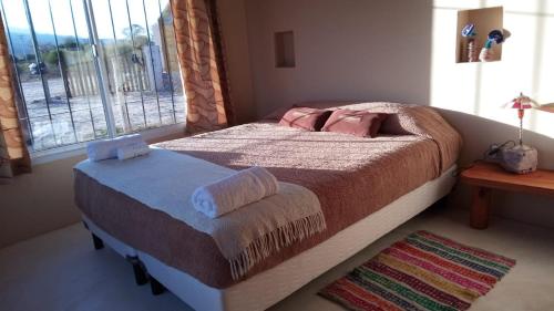 a bedroom with a large bed with a window at Cabaña Huacalera in Huacalera