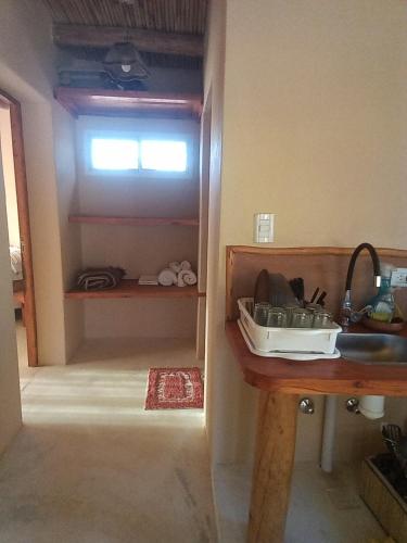 a kitchen with a sink and a table and a window at Cabaña Huacalera in Huacalera