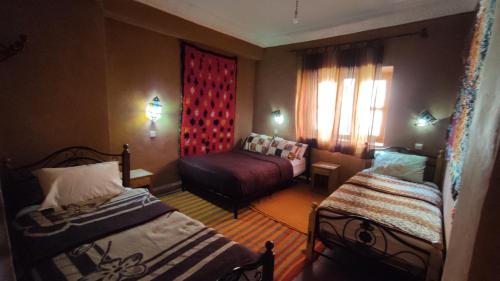 ein Hotelzimmer mit 2 Betten und einem Fenster in der Unterkunft La Belle étoile in Aït Oussane