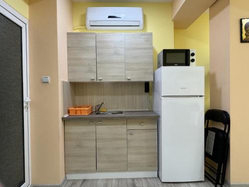 eine kleine Küche mit einem Kühlschrank und einer Mikrowelle in der Unterkunft Apartment Happy Place 2 in Weliko Tarnowo