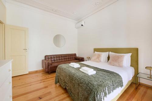 リスボンにあるLisbon Lodgeのベッドルーム(大型ベッド1台、革張りのソファ付)