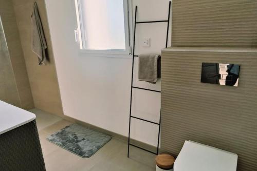 Elle comprend une petite salle de bains pourvue de toilettes et d'une fenêtre. dans l'établissement Maison moderne et lumineuse à 5 minutes à pied des plages, à Landunvez