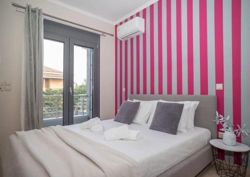 a bedroom with a bed with a red and white striped wall at La Vie Villa in Zakynthos Town