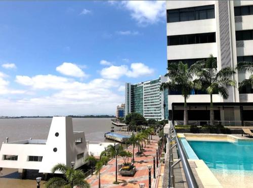 - Vistas al agua desde un edificio con piscina en Ecusuites Room 44 bellini Gye Santa Ana, en Guayaquil