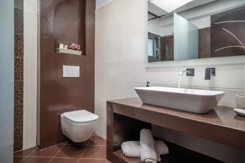 a bathroom with a sink and a toilet and a mirror at La Vie Villa in Zakynthos Town