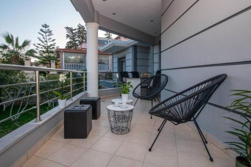 a patio with two chairs and a table on a balcony at La Vie Villa in Zakynthos Town