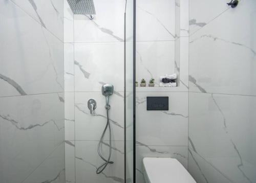 a white bathroom with a shower and a toilet at La Vie Villa in Zakynthos Town