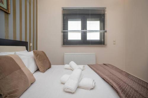 a white bed with towels on it with a window at La Vie Villa in Zakynthos Town