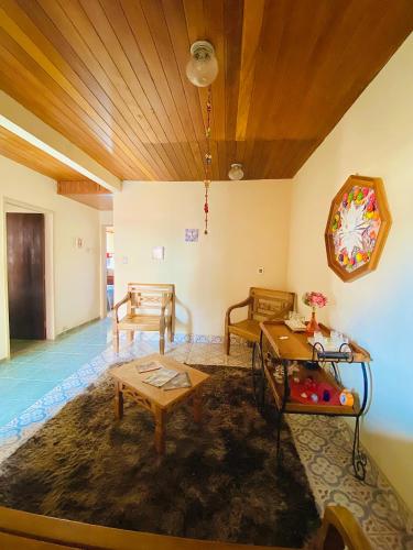 a living room with two chairs and a table at Hospedaria Vila Rica - 1 km do centro histórico in Ouro Preto