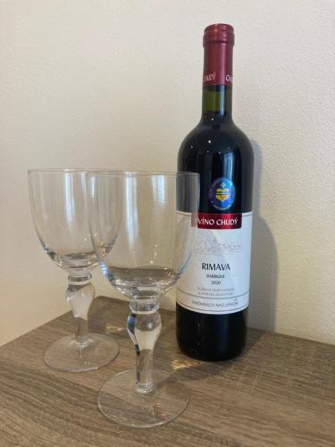 a bottle of wine and two wine glasses on a table at Apartmán neďaleko centra mesta in Michalovce